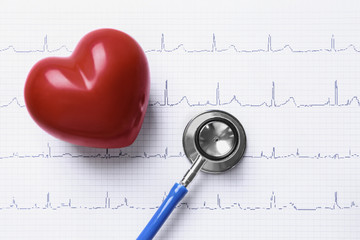 Stethoscope and red heart on paper electrocardiogram