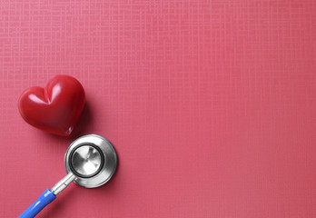 Stethoscope and red heart on table
