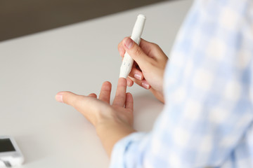 Woman using lancelet on finger