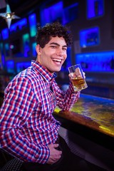 Portrait of man with beer laughing at bar counter