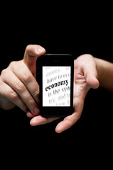 Hands Holding Smartphone, showing  the word Economy printed