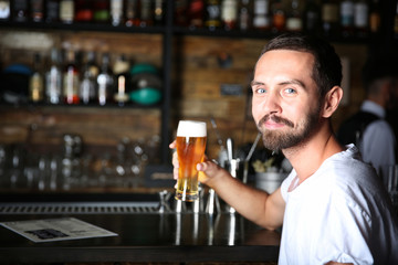 Man drinking beer at bar counter