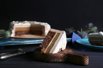 Slice of delicious cake with chocolate, nuts and pear topping on wooden board