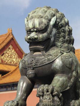 Outside the Chinese Imperial Palace, a Chinese Guardian Lion, a Foo Dog with her left paw on a small cub.