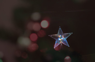 Christmas star tree topper with colorful light bokeh on dark background