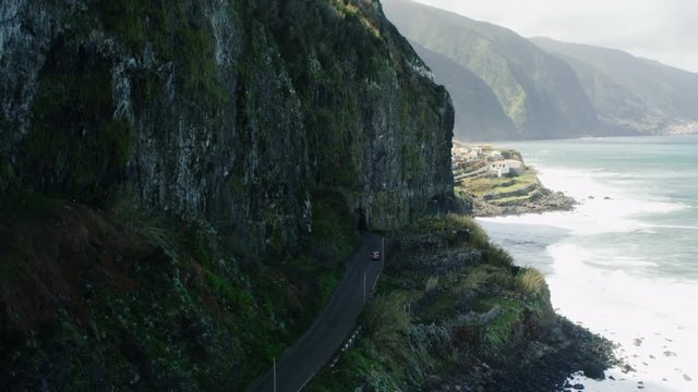 Car Going Near the Sea Along Mountain Slopes. Aerial Shot from Madeira.