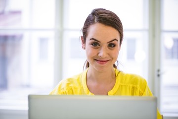 Portrait of confident businesswoman with laptop at office