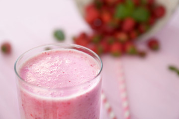 Milk cocktail with strawberry on table, closeup