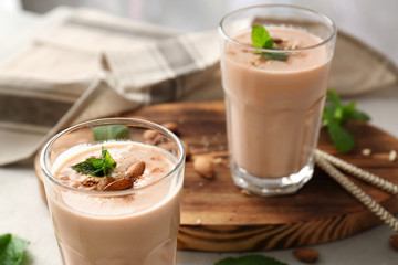 Glasses with delicious nut milk shake on table, closeup