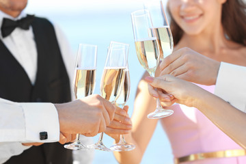 People clinking glasses at party outdoors, close up view