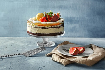 Delicious creamy cake with figs and berries on light grey background