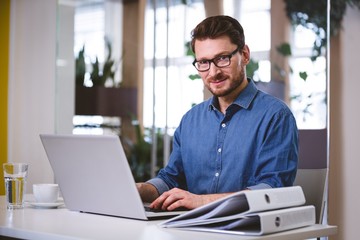 Fototapeta premium Portrait of businessman working on laptop 