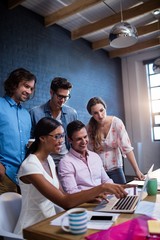 Group of coworkers watching a laptop