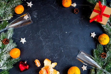 glasses and Christmas ornaments on dark background top view