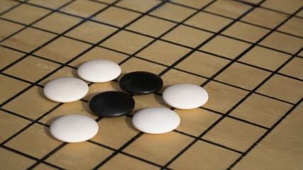 Chinese Go or Weiqi board game. Atari position with group. Outside activity