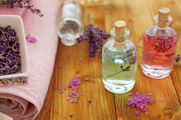 Obraz na płótnie Canvas Bottles with lavender oil on wooden background