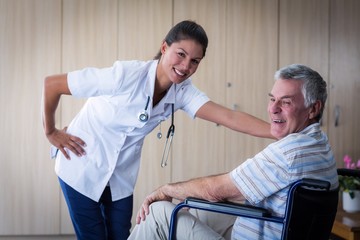Obraz premium Portrait of smiling senior man and female doctor in living room