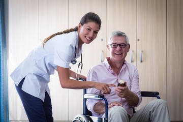 Obraz premium Portrait of female doctor giving medicine to senior man