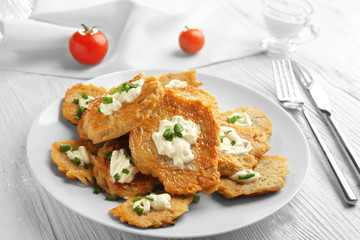 Plate with tasty potato pancakes for Hanukkah on wooden table