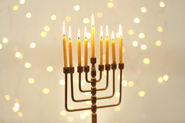 Fototapeta premium Menorah with candles for Hanukkah against defocused lights