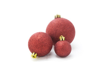 Three red christmas baubles isolated on white background