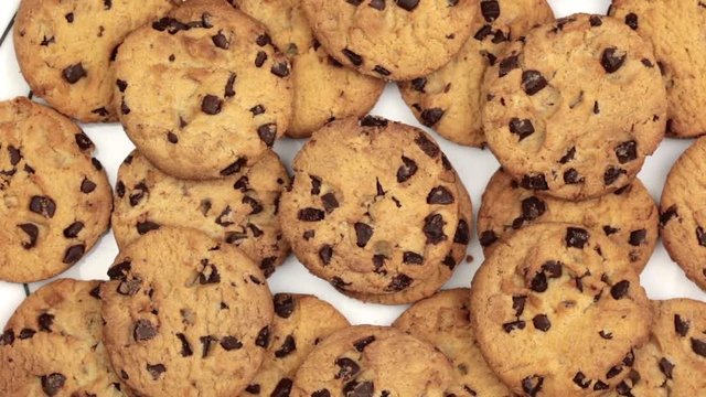 Freshly baked golden brown chocolate chip cookies rotating on a plate