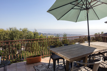 Obraz premium Umbrella and wooden table on outdoor terrace / deck.