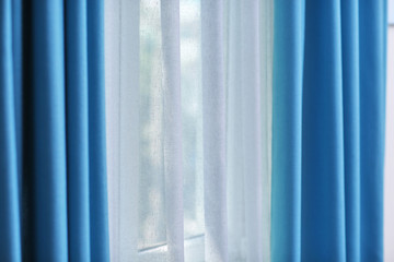 Obraz premium Room window with white and blue curtains, close up