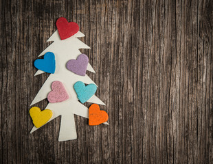 Christmas tree made of paper and hearts on wooden background
