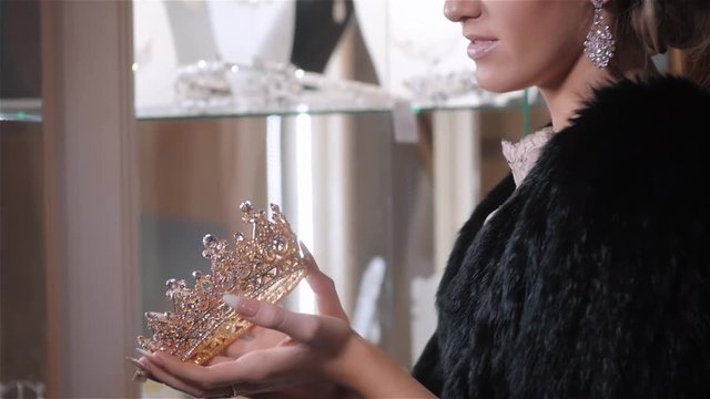woman chooses bridal accessories in wedding boutique and wear crown with diamonds