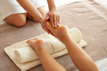 Spa concept. Hands massaging female feet with scrub