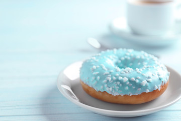 Plate with donut and cup of coffee on background
