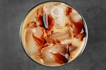 Iced coffee with milk on grey background