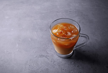 Iced coffee with milk on grey background