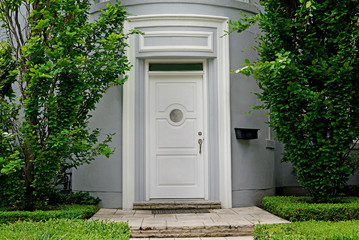 white front door framed by trees