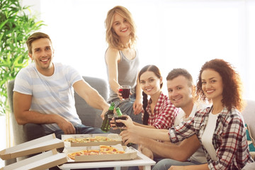 Friends toasting with drinks at home party