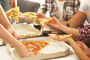 Friends eating pizza at home party, closeup