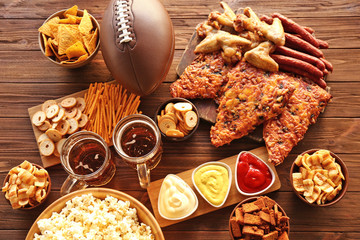 Fototapeta premium Table full of tasty snacks and beer prepared for watching rugby on TV