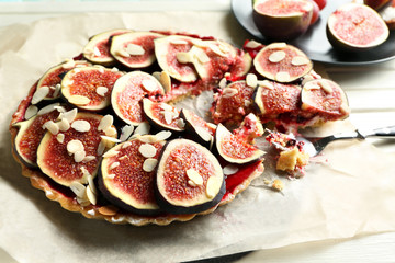 Delicious fig cake with almond flakes on parchment, closeup