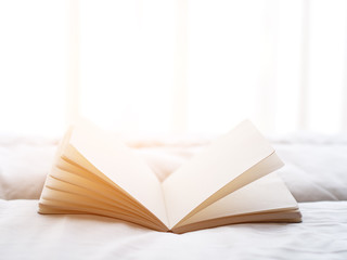 Fresh morning read book on the bed, soft focus.