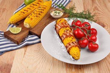 Tasty grilled corns on table