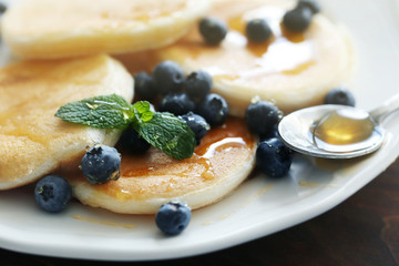 Tasty pancakes with blueberry on kitchen table