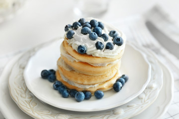 Tasty pancakes with blueberry on kitchen table