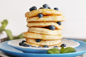 Tasty pancakes with blueberry on plate