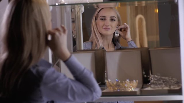 woman chooses bridal accessories in wedding boutique and wear crown with diamonds