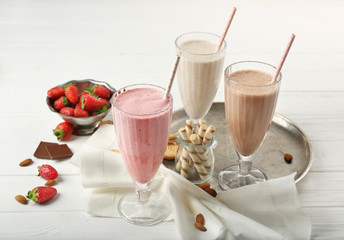 Tasty cocktails with sweets and berries on wooden background