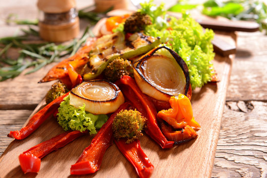 Grilled vegetables on wooden cutting board, closeup