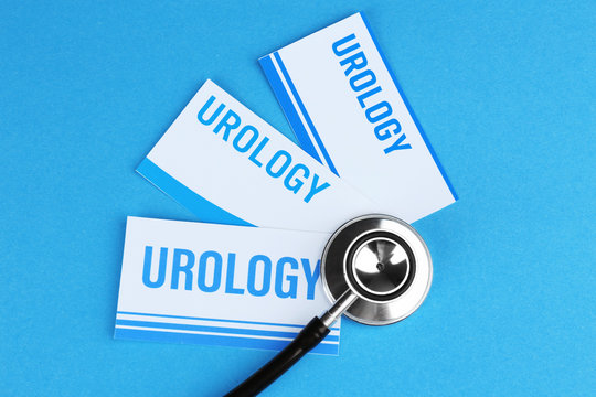 Medical stethoscope and cards with word UROLOGY on blue background