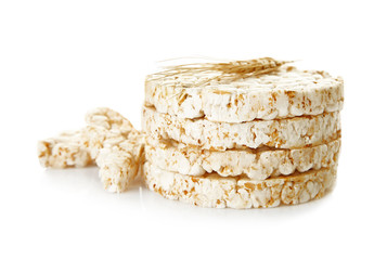 Round rice crispbreads and spikelets on white background