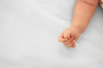 Baby hand on bed, closeup